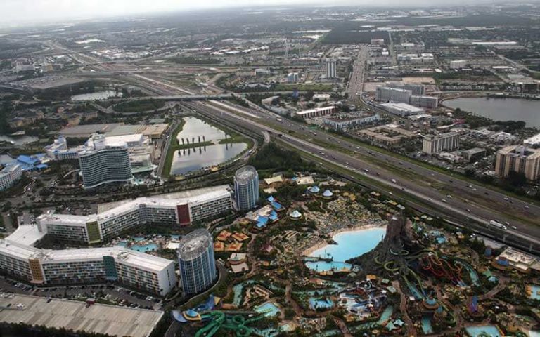 aerial of skyline over orlando with volcano bay at universal resort for maxflight helicopter tours