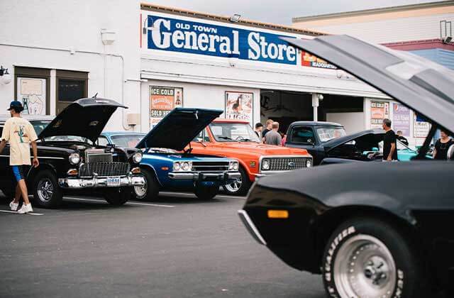 auto show with rows of classic cars with hoods open along street at old town entertainment district kissimmee