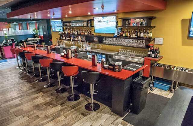 bar with stools and large liquor selection on the back wall at black fire brazilian steakhouse orlando