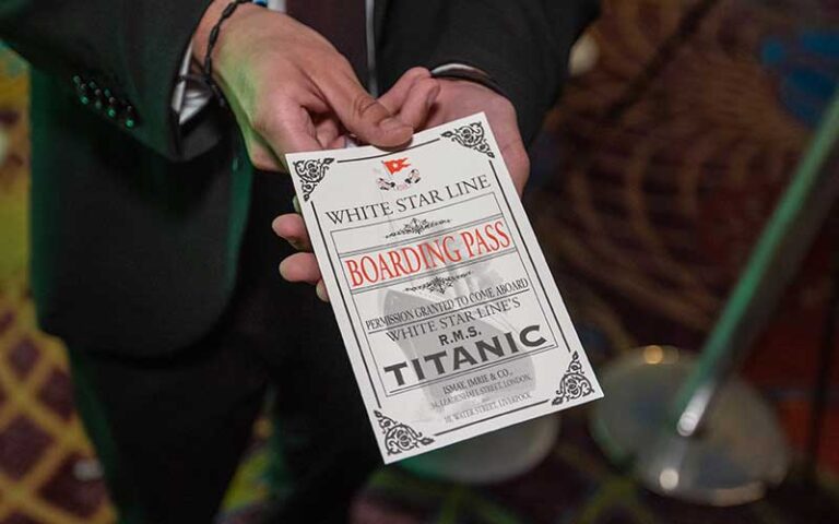 boarding pass program in mans hand at titanic the artifact exhibition orlando