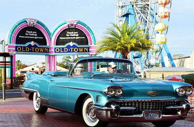 classic blue cadillac show car with old town gateway and ferris wheel at old town entertainment district kissimmee