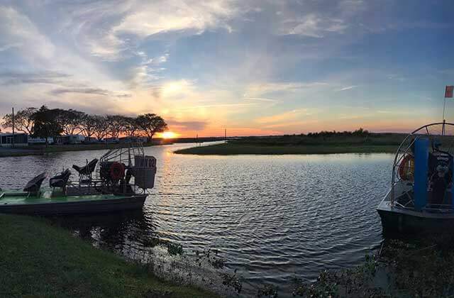 colorful sunset over the water with airboats at wild willys airboat tours st cloud