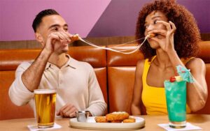 couple sharing cheese sticks with drinks in booth at dave busters orlando