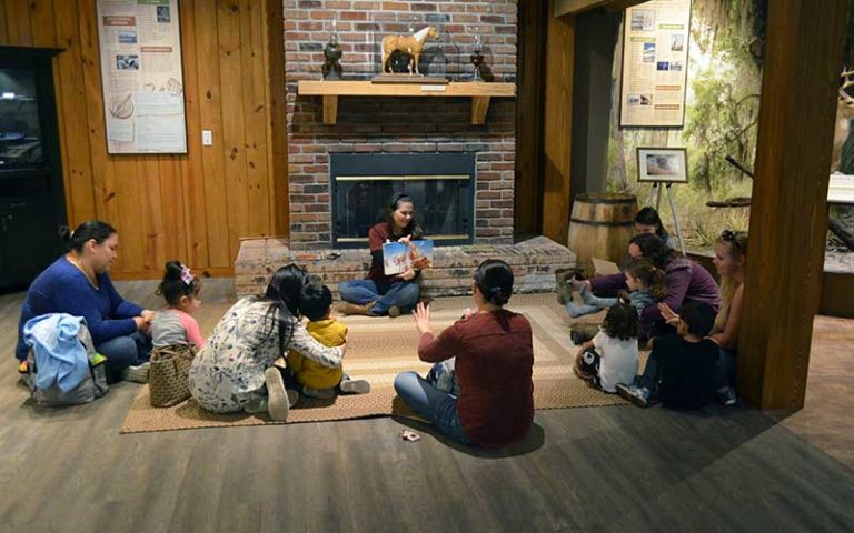 families and kids seated on the floor for story telling at osceola county welcome center history museum