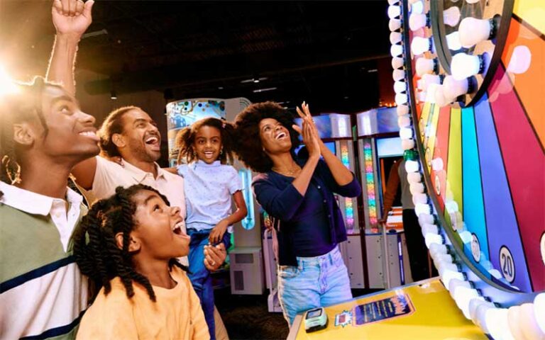 family cheering while playing carnival arcade game at dave busters orlando
