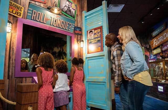 family of five laughing at an exhibit in a museum at ripleys believe it or not orlando