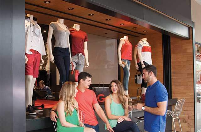 family of shoppers standing in front of display window at lake buena vista factory stores