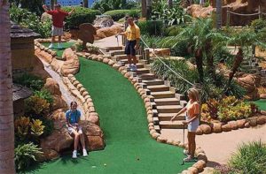 family plays mini golf down a steep green at congo river golf orlando kissimmee