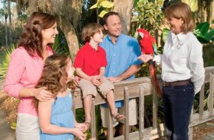 family with guide holding a parrot at central florida zoo botanical gardens sanford