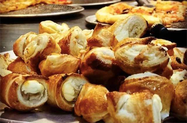 garlic knots platter with pizza in background oreganatta italian buffet orlando