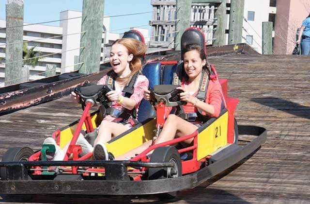 girls riding tandem go kart on wooden track magical midway orlando