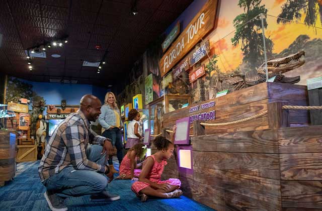 girls watching gators through exhibit windows with parents at ripleys believe it or not orlando