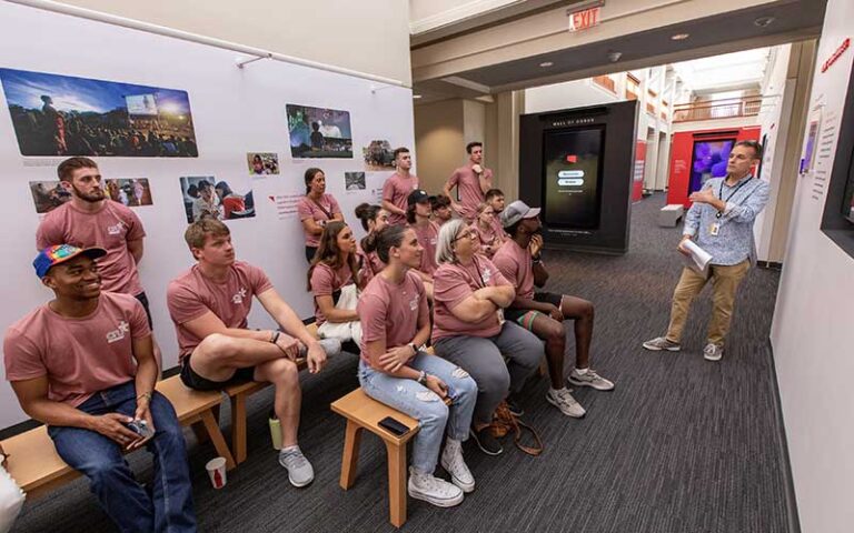 guide speaking to group in exhibit room at jesus film project tour