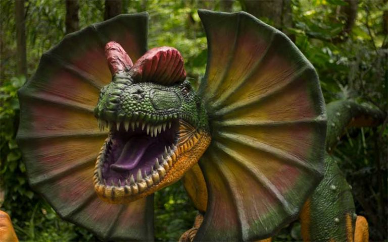 life size model of dinosaur with hooded face screeching in wooded area at dinosaur world