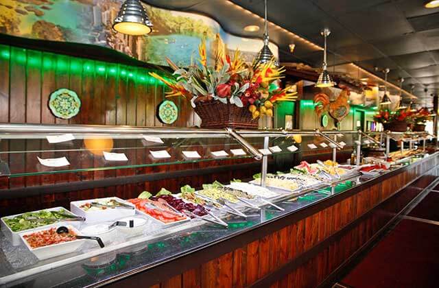 long buffet bar with green and red lighting at cafe mineiro brazilian steakhouse orlando