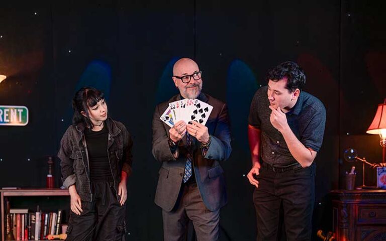 magician holding cards with volunteer couple at outta control magic comedy dinner show orlando