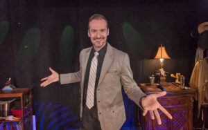 magician posing between dining tables at outta control magic comedy dinner show wonderworks orlando