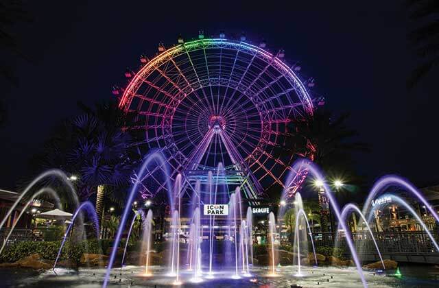 night view of the wheel with colorful lighting and fountains at the wheel at icon park orlando