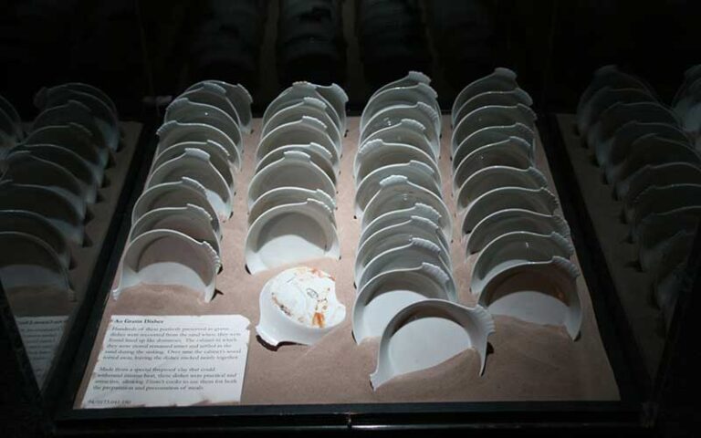 rows of dishes under glass case at titanic the artifact exhibition orlando