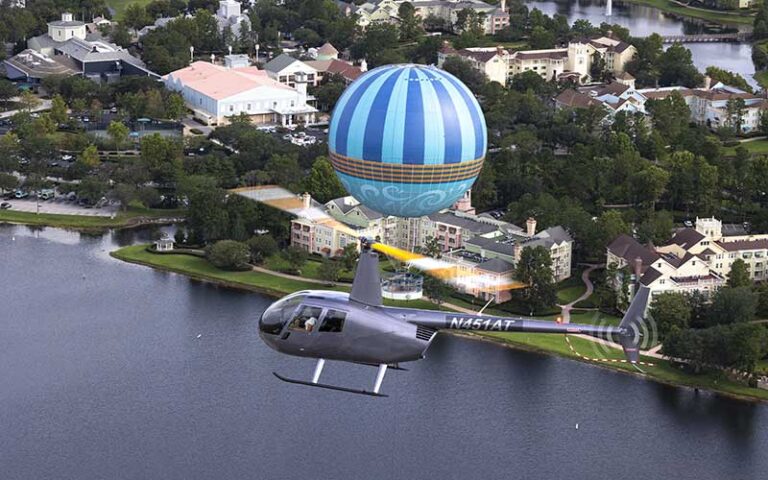 silver helicopter flying over disney springs balloon ride at maxflight helicopter services kissimmee