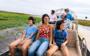 smiling family on speeding airboat with headgear at wild florida