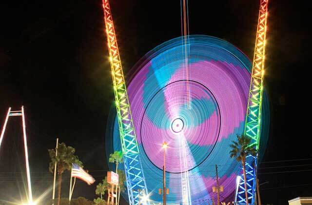 spinning ride with blurred lighting at night with attractions at slingshot vomatron old town kissimmee