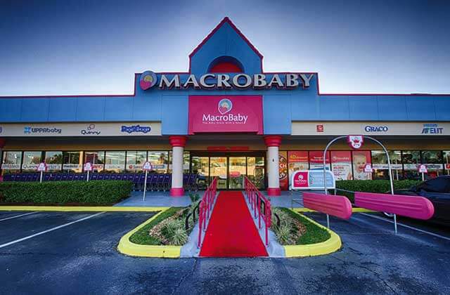 storefront exterior with blue and pink signs parking and carts at macrobaby store orlando