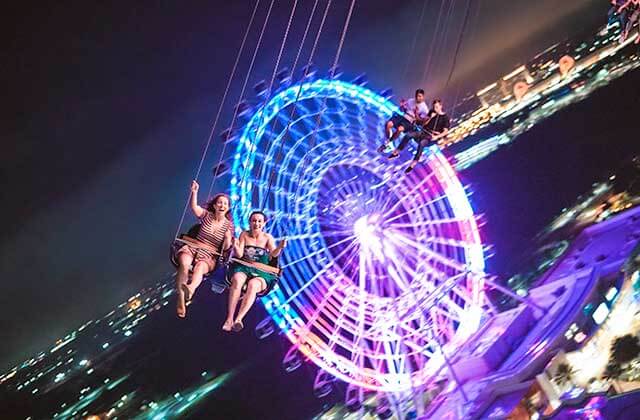 swing riders at night with wheel in the background at orlando starflyer