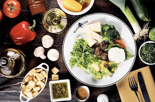 tabletop with plate and fresh salad ingredients at black fire brazilian steakhouse orlando