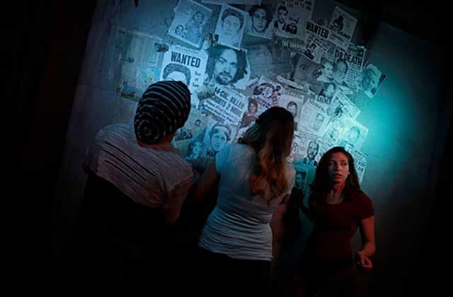 three girls searching for clues in articles on wall lockbusters escape game orlando