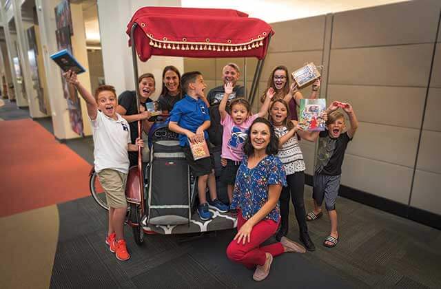 tour group family around pedicab inside at jesus film project orlando