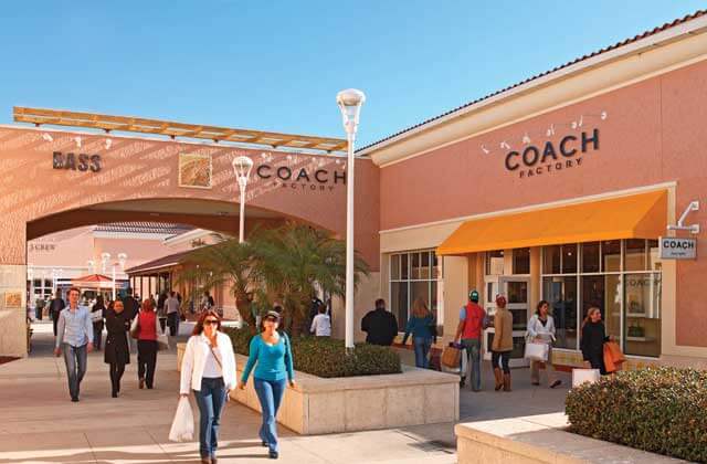 two women walking through crowded outdoor shopping center at orlando vineland premium outlets