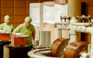 two women working with vats of liquid chocolate at chocolate kingdom