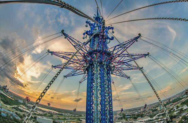 view from seat of tower with riders and sunset skyline at orlando starflyer