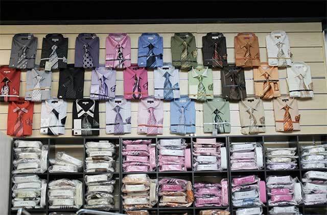 wall rack display with selection of collared dress shirts and ties at orlandos gk menswear store