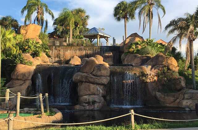waterfalls with large rocks and tropical foliage at lost caverns adventure golf orlando
