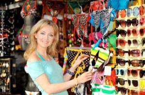 woman shops for bathing suit and sunglasses at maingate flea market kissimmee