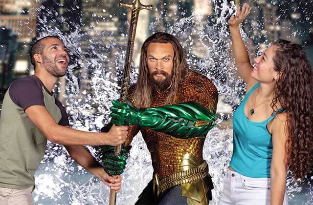 young couple pose with aquaman wax figure madame tussauds orlando