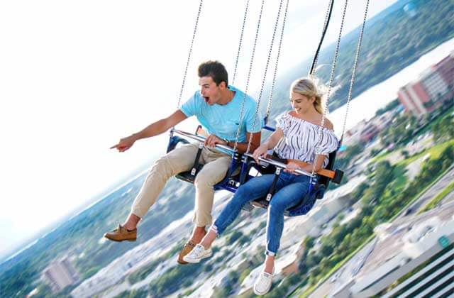 young couple riding double seat with skyline view orlando starflyer