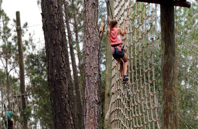 young lady climbs along rope net orlando tree trek adventure park kissimmee