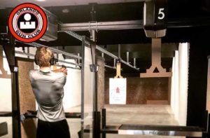 young man aims handgun at target gallery at orlando gun club