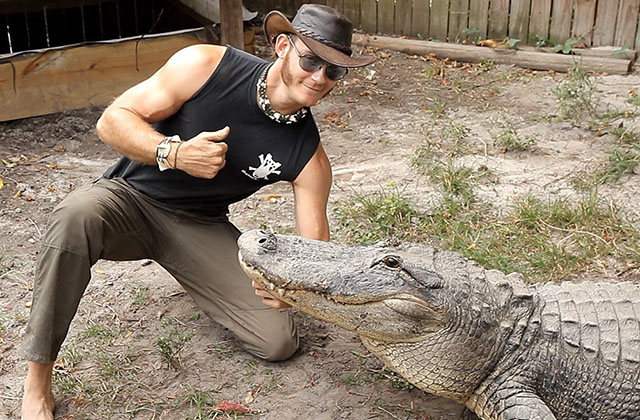 Alligator handler poses with giant alligator at Everglades Holiday Park