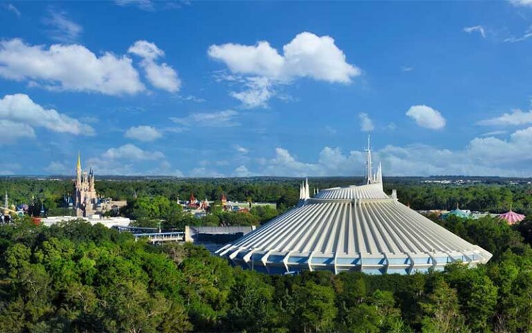 aerial daytime view over trees of white space mountain dome and castle at magic kingdom walt disney world resort orlando