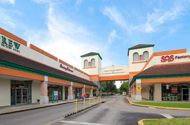 arched entrance with parking and storefronts at st augustine premium outlets florida