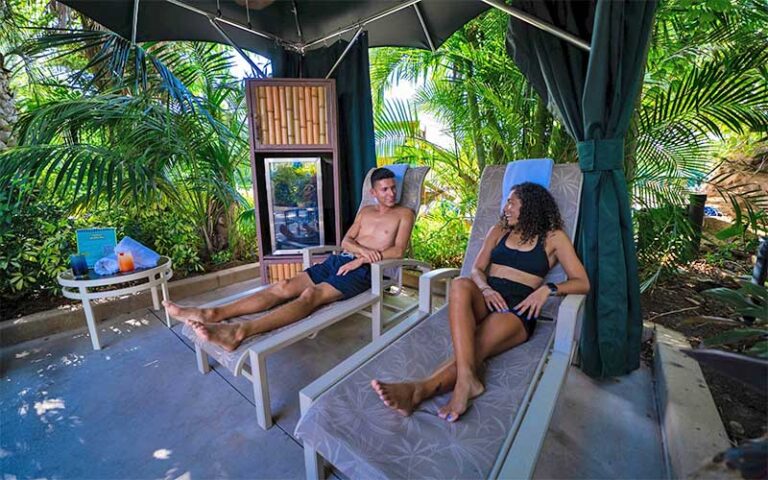 couple on loungers in cabana at aquatica orlando