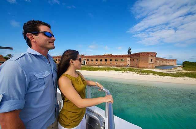 couple standing on boat deck looking at fort at dry tortugas national park ferry key west