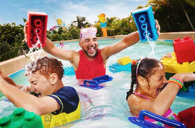 dad splashes kids on lazy river in water park at legoland florida resort