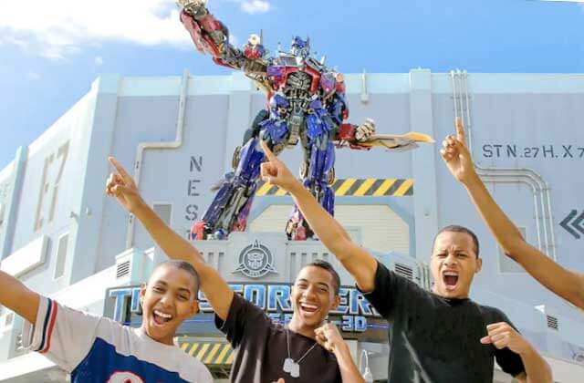 exterior of transformers ride with boys imitating optimus prime at universal studios florida theme park orlando