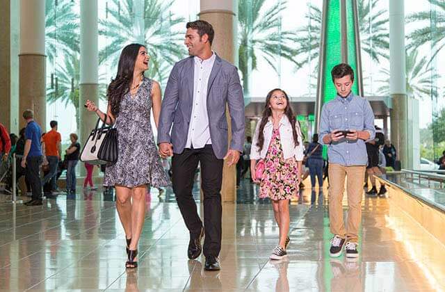 family of four strolls through atrium at mall at millenia orlando