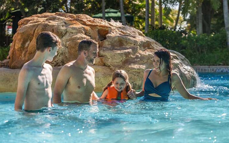 family of four in lazy river at aquatica orlando